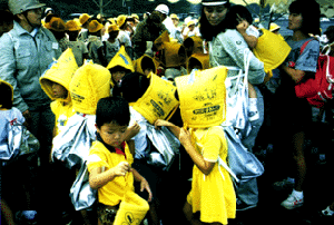  Children don protective hats in a disaster drill.
(Tokyo Metropolitan Government) 